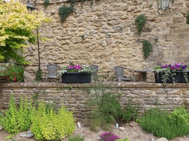 A garden with seating and planters at Jasmine Cottage South Perrott near Mosterton