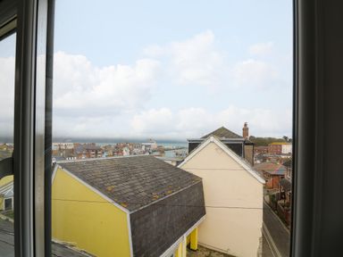 View through a window of rooftops and buildings with a street and harbor in the background at Harbour Reach Brewers Quay Harbour