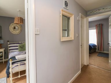 A hallway with a mirror on the wall between two bedrooms at Harbour Reach in Brewers Quay Harbour