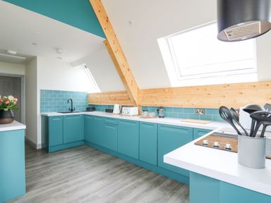 A kitchen with teal cabinets and a white countertop at Kerry Hill - The Sheepfold in Llanyre near Llandrindod Wells
