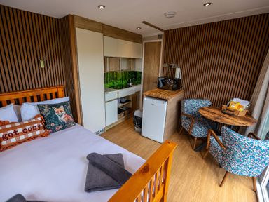 A bedroom with a bed and kitchenette at The Fox Den Nantmel near Rhayader