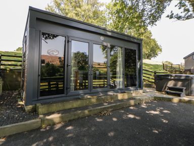 A building with large doors and a hot tub at The Fox Den Nantmel near Rhayader