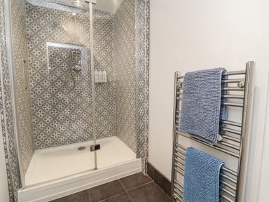 A shower with patterned tiles and a towel rack at Ferndale in Lynton