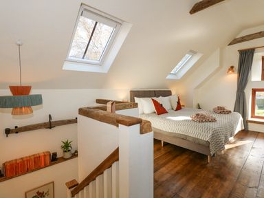 A bedroom with a bed and pillows under skylight windows at The Little Hay Barn in Bacton