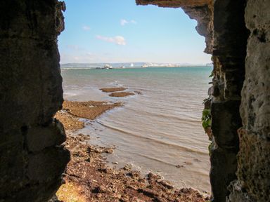 A view of the sea and shoreline through a stone opening at Castle Cove View in Castle Cove