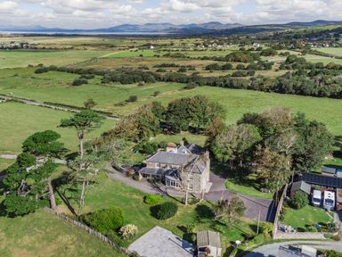 A rural property with a stone house surrounded by trees and fields at Bennar Fawr in Dyffryn Ardudwy