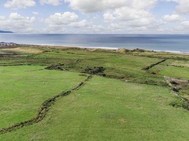 Green fields with some sheep near the coastline and ocean at Bennar Fawr in Dyffryn Ardudwy