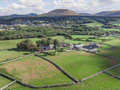 A rural landscape with fields divided by stone walls and farm buildings at Bennar Fawr in Dyffryn Ardudwy