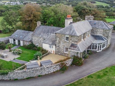 A large stone house with a driveway garden and surrounding trees at Bennar Fawr in Dyffryn Ardudwy