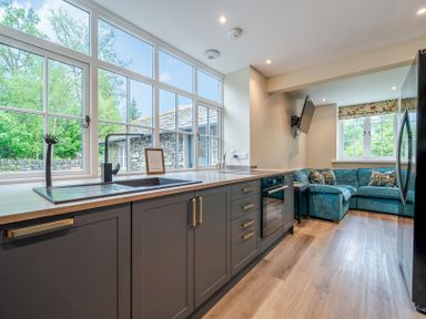 A kitchen with a sink and cooking area at Home Farmhouse at the Graythwaite Estate near Hawkshead