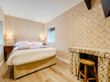 A bedroom with a bed and nightstand at Home Farmhouse at the Graythwaite Estate near Hawkshead