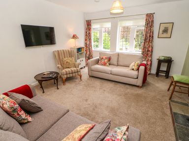 A living room with two sofas armchair and wall mounted television at The Coach House Shepherd's Dene near Corbridge