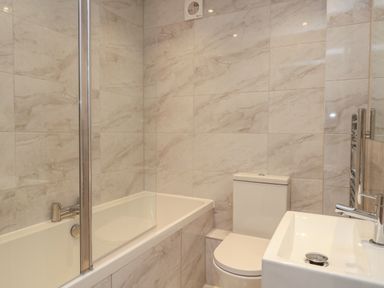 A bathroom with a bathtub shower toilet and sink at Harbourside Haven Apartment 2 Weymouth