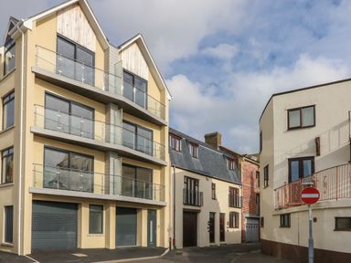 A street view with modern and traditional buildings and a no entry traffic sign at Harbourside Haven Penthouse 1 in Weymouth