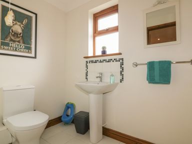 A bathroom with a toilet sink mirror towel and a framed picture at Meadowside in Goonhavern