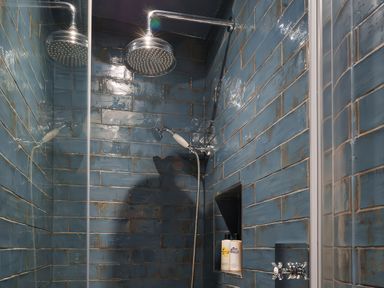 A shower with blue wall tiles and a shower head at Reybridge House in Lacock