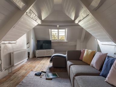 A living room with a sofa and television at Reybridge House in Lacock