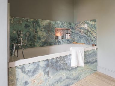 A bathroom with a bathtub and bath products at Reybridge House in Lacock