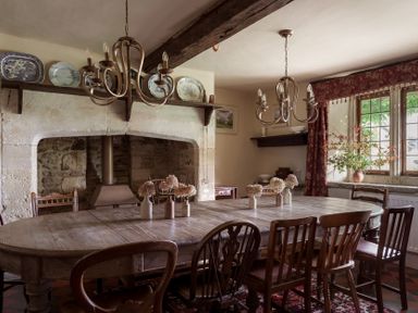 A dining room with a wooden table and chandelier at Reybridge House in Lacock