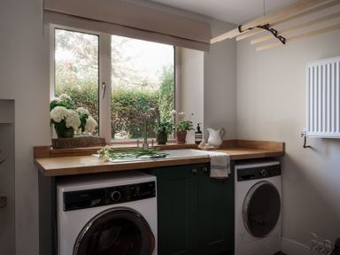 A laundry room with two appliances and plants at Reybridge House in Lacock