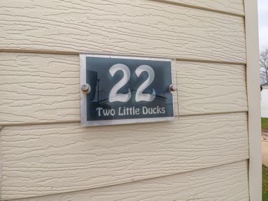 House number 22 with two little ducks sign on beige exterior wall at Two Little Ducks in Cayton