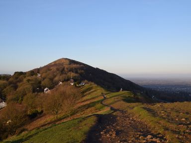 A hill with a walking path and scattered houses near the base at The Escape in Malvern