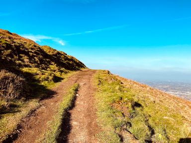 A path on a hillside under a clear blue sky at The Escape in Malvern