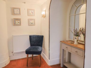 A hallway with a chair, table, and photographs at Garden View in Wellington