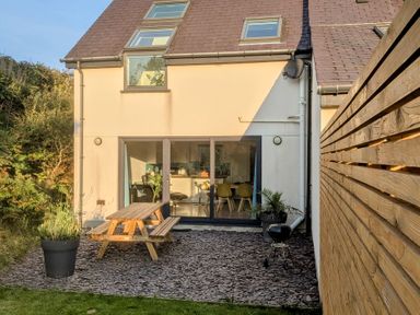 A garden with a picnic table and planter at Hen Gapel Waunfawr, Gwynedd