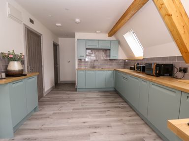 A kitchen with wooden countertops and light blue cabinets at Brecknock Cheviot - The Sheepfold in Llanyre near Llandrindod Wells