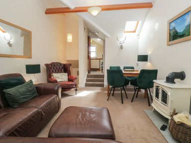 A living room with a sofa and dining area at Walkers Retreat Keswick
