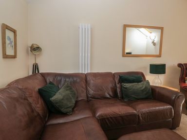 A living room with a brown sofa and decorative items at Walkers Retreat in Keswick