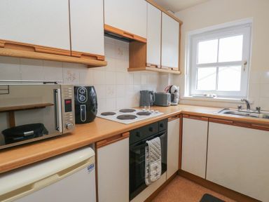 A kitchen with a stove, microwave, and sink at Walkers Retreat in Keswick