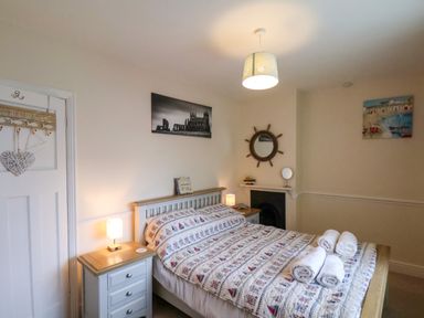 A bedroom with a double bed and rolled towels on it at Over Esk in Whitby