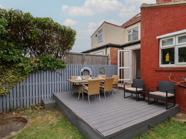 A garden with a deck and outdoor furniture at Over Esk Whitby