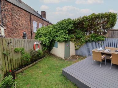 A garden with a deck and furniture at Over Esk in Whitby
