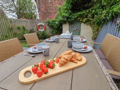 An outdoor dining area with a table set for breakfast at Over Esk Whitby