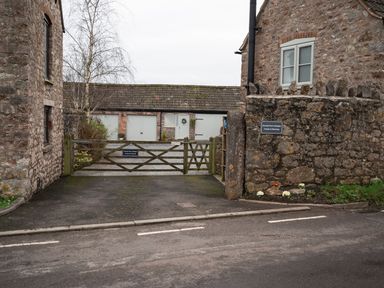 A stone courtyard with wooden gates and a gravel driveway at Dunnet Farm Cottages Crooks and Wavering