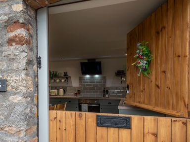 A kitchen with a wooden half door stone wall and kitchen appliances at Wavering in Compton Bishop near Axbridge