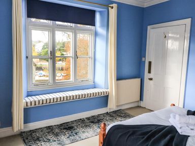 A bedroom with a window seat cushion and a bed at Victoria Lodge in Kingsbridge