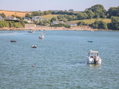A bay with boats on water and houses and trees on the shore at Victoria Lodge in Kingsbridge