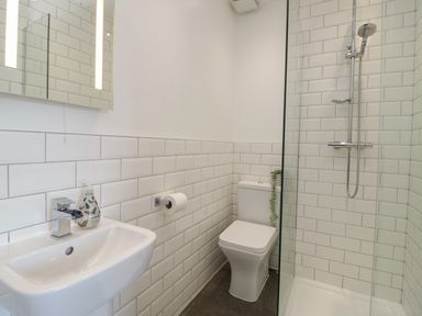 A bathroom with a sink a toilet and a glass shower area at Monarfon in Amlwch