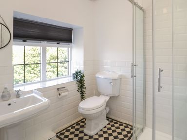 A bathroom with a toilet sink window and shower at Monarfon in Amlwch