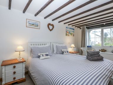 A bedroom with a double bed and bedside table at Ty Gwennol in Llanfaethlu