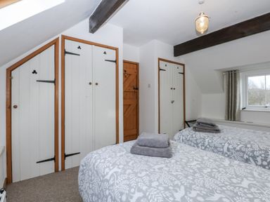 A bedroom with two beds and wardrobes at Ty Gwennol in Llanfaethlu
