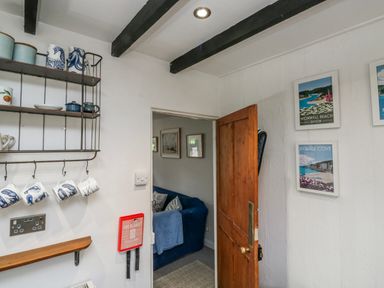 An entryway with shelves and mugs at 3 Rock Cottages in Kingston