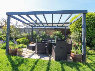 A garden with a seating area under a pergola at 3 Rock Cottages Kingston