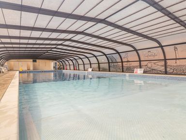 An indoor swimming pool with a glass roof and walls with illustrations at 91 Waterside Park in Lowestoft