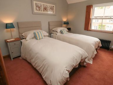 A bedroom with two single beds with bedside tables and lamps at Ascot Cottage Sheriff Hutton near Strensall