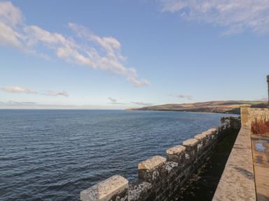 A stone wall overlooking a large body of water with hills in the background at Ardlochan Lodge - Culzean Castle in Maybole